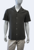 Mannequin wearing a dark textured shirt with buttons on a white background