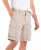 Beige cargo shorts worn by a person on a white background