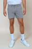 light grey shorts on model against tan background