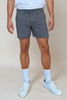 Person wearing gray shorts, white socks, and white sneakers on a beige background