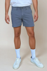man wearing slate color shorts on cream background