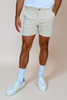 string color shorts on model against tan background