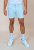 Person wearing light blue shorts and shoes on a beige background