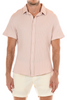 Man wearing a pink short-sleeve shirt and white shorts on a white background