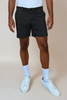 Person wearing black shorts, white sneakers, and light blue socks on a beige background