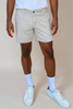model wearing bone color shorts on tan background