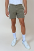 Person wearing olive shorts, white socks, and white sneakers on a plain background
