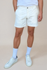 Person wearing white shorts and white sneakers on a beige background