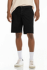 Person wearing black shorts and white sneakers on a white background