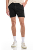 Person wearing black shorts and white sneakers on a white background